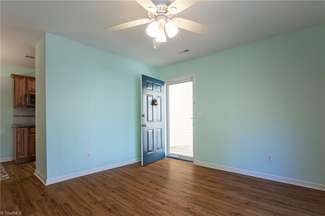 unfurnished room with ceiling fan and dark hardwood / wood-style flooring