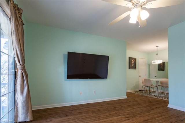 unfurnished living room featuring dark wood-type flooring, ceiling fan, and plenty of natural light