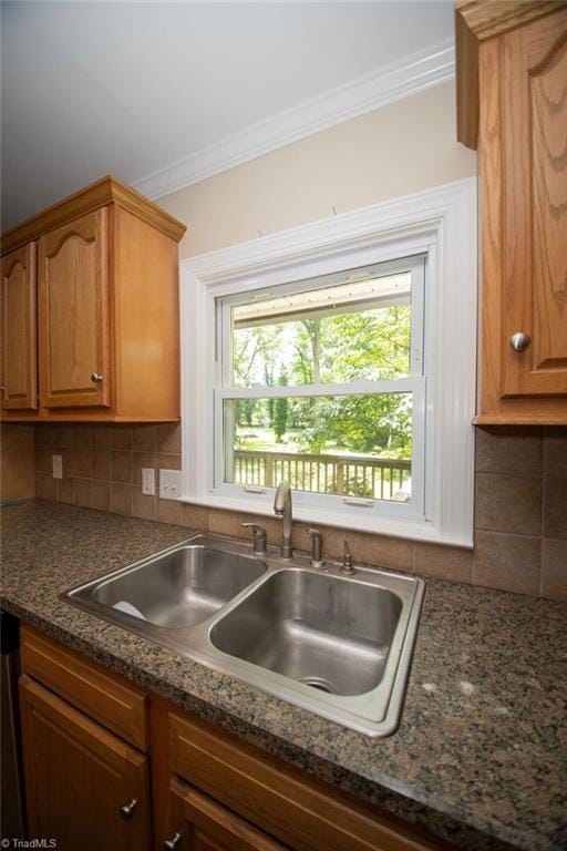7040 Franklin Rd, Lewisville, NC 27023 - kitchen featuring crown molding, plenty of natural light, tasteful backsplash, brown cabinetry, and dark stone counters