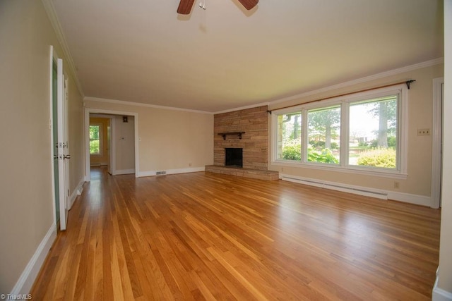 7040 Franklin Rd, Lewisville, NC 27023 - unfurnished living room featuring a baseboard radiator, light wood finished floors, ornamental molding, ceiling fan, and a fireplace