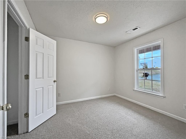 spare room with carpet and a textured ceiling