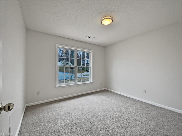 spare room with a textured ceiling and carpet