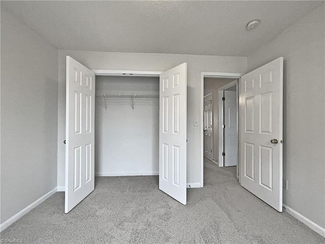 unfurnished bedroom with light carpet and a closet