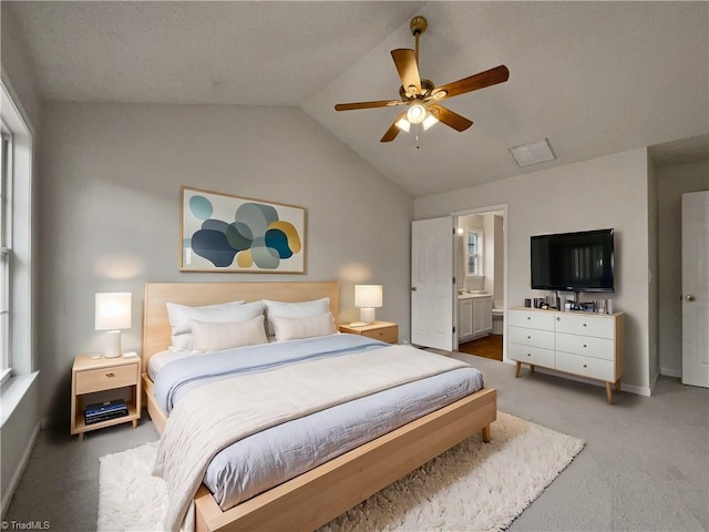 carpeted bedroom featuring lofted ceiling, ceiling fan, and ensuite bathroom