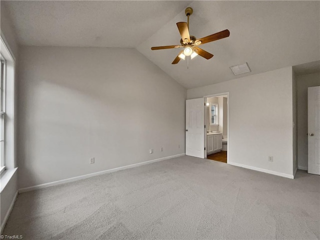 empty room with dark colored carpet, vaulted ceiling, and ceiling fan