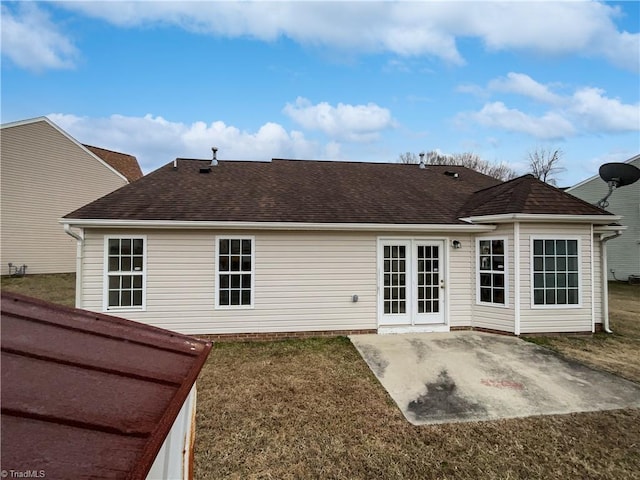 back of property with a patio, a lawn, and french doors