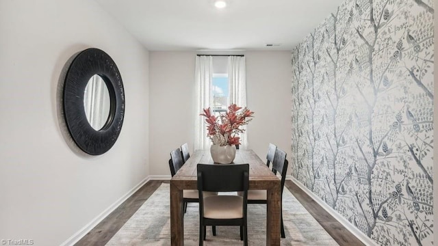 dining space with dark wood-style flooring and baseboards