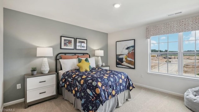 bedroom with baseboards, visible vents, and light carpet