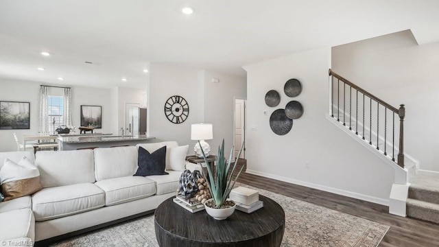 living room featuring baseboards, recessed lighting, wood finished floors, and stairway