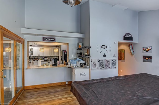 bedroom with stainless steel refrigerator with ice dispenser, light hardwood / wood-style flooring, and billiards