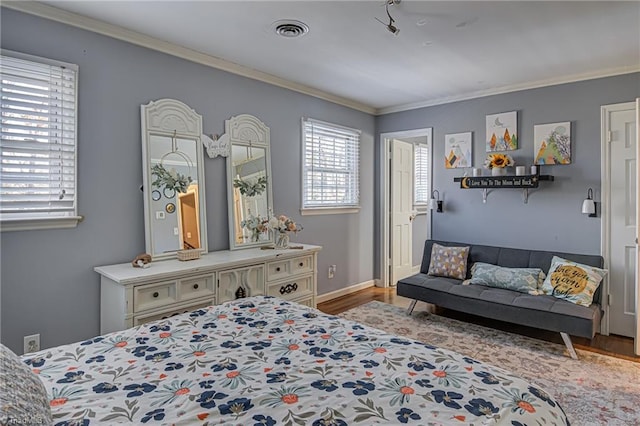 bedroom featuring light wood-type flooring and crown molding