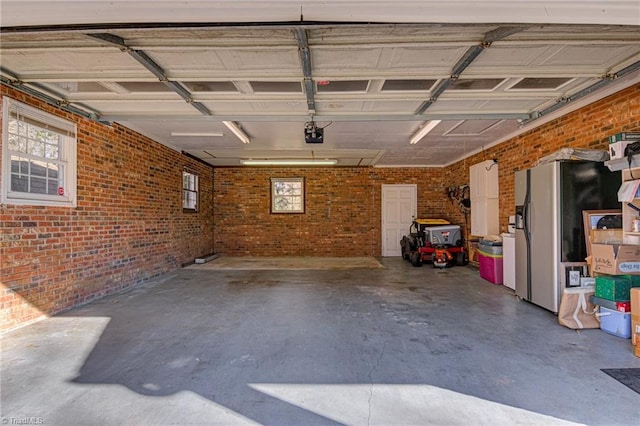 garage featuring stainless steel refrigerator with ice dispenser and a garage door opener