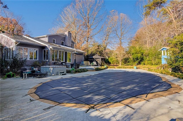 view of swimming pool with a patio area and a hot tub