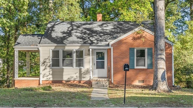 view of front of property with brick siding, roof with shingles, crawl space, a chimney, and a front yard