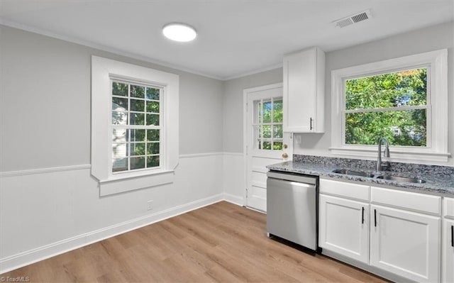 kitchen featuring light stone counters, a wainscoted wall, a sink, visible vents, and dishwasher