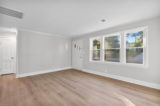 interior space with visible vents, crown molding, light wood-style flooring, and baseboards