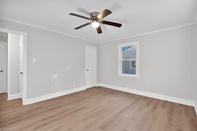 unfurnished room featuring ornamental molding, wood finished floors, and baseboards