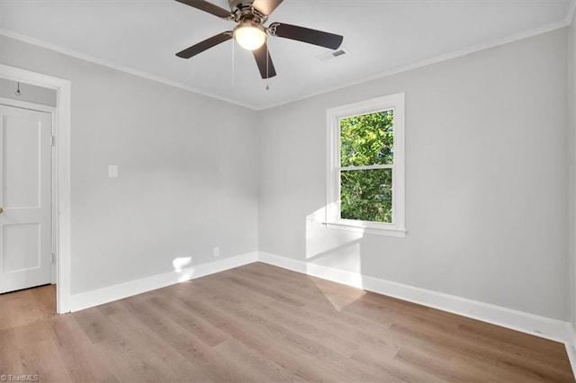 empty room with visible vents, baseboards, ceiling fan, wood finished floors, and crown molding