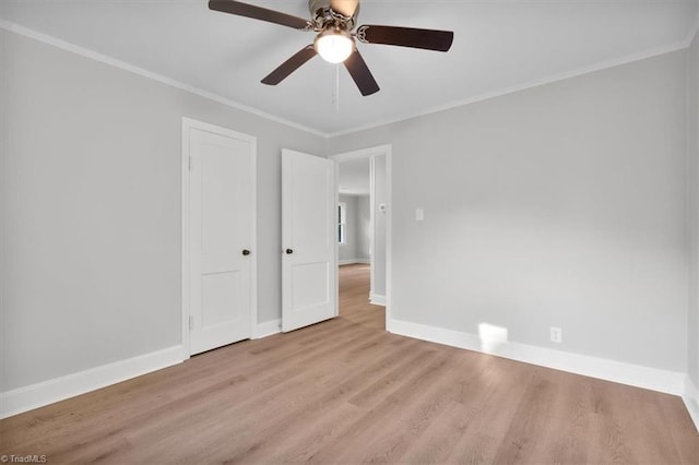 unfurnished bedroom featuring wood finished floors, a ceiling fan, baseboards, a closet, and crown molding