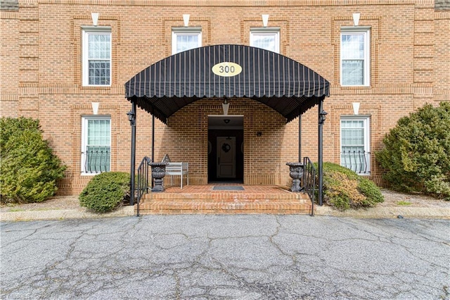 doorway to property with brick siding