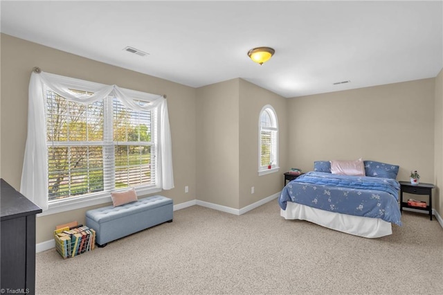 bedroom with baseboards, visible vents, multiple windows, and carpet