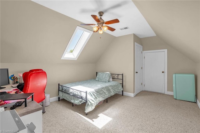 bedroom featuring carpet flooring, vaulted ceiling with skylight, visible vents, ceiling fan, and baseboards