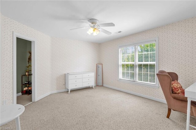 interior space featuring carpet, visible vents, a ceiling fan, and wallpapered walls