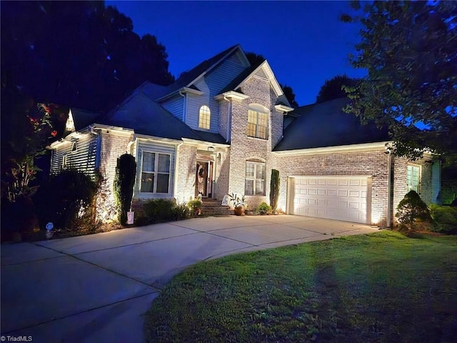 traditional-style home with concrete driveway, a yard, brick siding, and a garage
