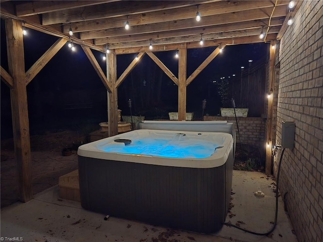 patio at twilight featuring a hot tub