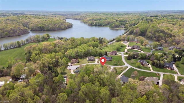 birds eye view of property with a wooded view and a water view