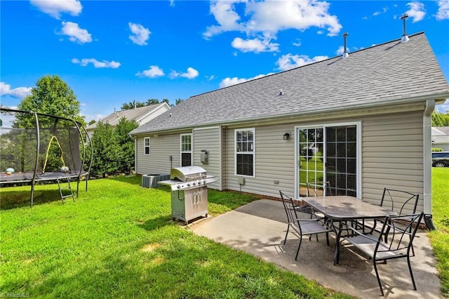 5803 Sycamore Glen Rd, Greensboro, NC 27405 - rear view of house with a trampoline, a patio, roof with shingles, and a yard