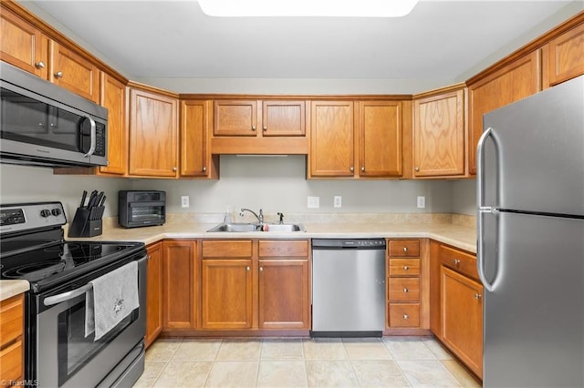 5803 Sycamore Glen Rd, Greensboro, NC 27405 - kitchen featuring appliances with stainless steel finishes, light countertops, and brown cabinetry