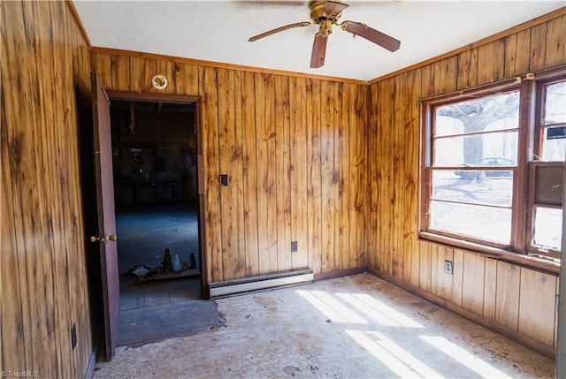 unfurnished room featuring a healthy amount of sunlight, a baseboard heating unit, baseboards, and wooden walls