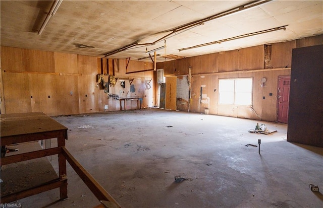 miscellaneous room featuring wooden walls, a garage, and concrete flooring