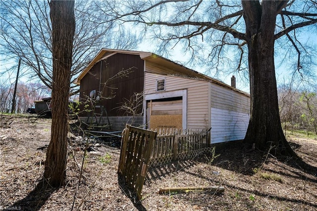 view of outbuilding with fence and an outbuilding