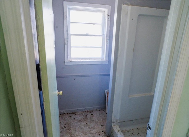 bathroom with a shower stall and baseboards