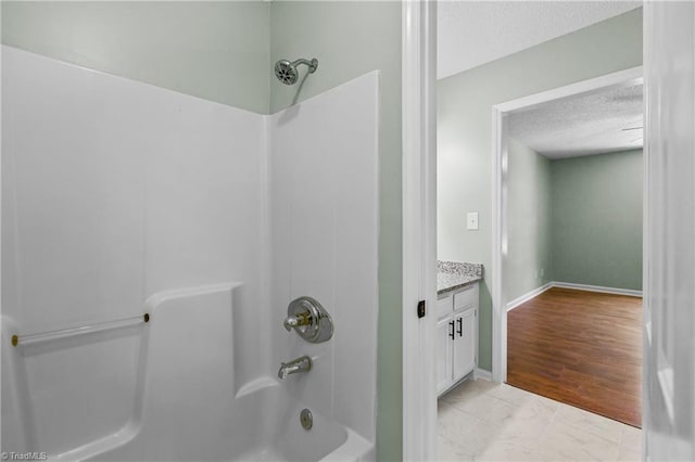 1650 Billy Dr, Winston-Salem, NC 27107 - bathroom featuring washtub / shower combination, a textured ceiling, vanity, and marble look tile flooring