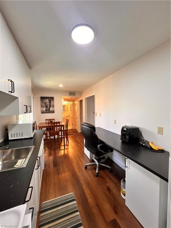 home office with dark hardwood / wood-style flooring