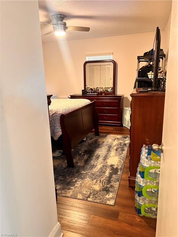 bedroom with ceiling fan and dark hardwood / wood-style flooring