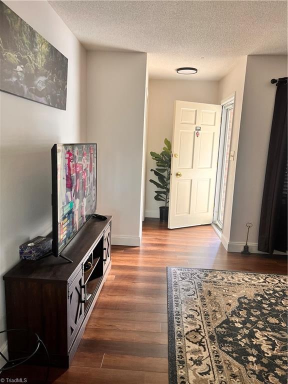 foyer entrance featuring a textured ceiling and dark hardwood / wood-style flooring