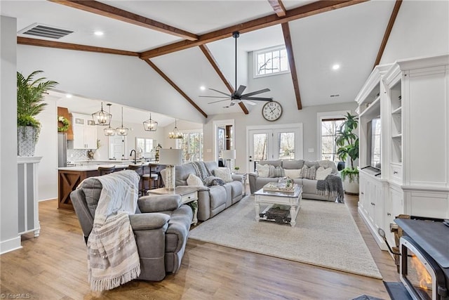 living room with sink, light hardwood / wood-style flooring, beam ceiling, high vaulted ceiling, and ceiling fan with notable chandelier