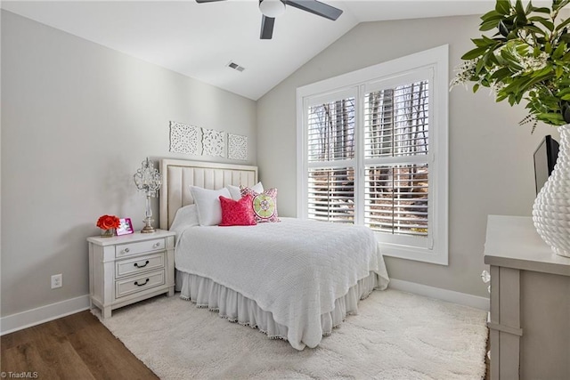 bedroom with ceiling fan, lofted ceiling, multiple windows, and light wood-type flooring