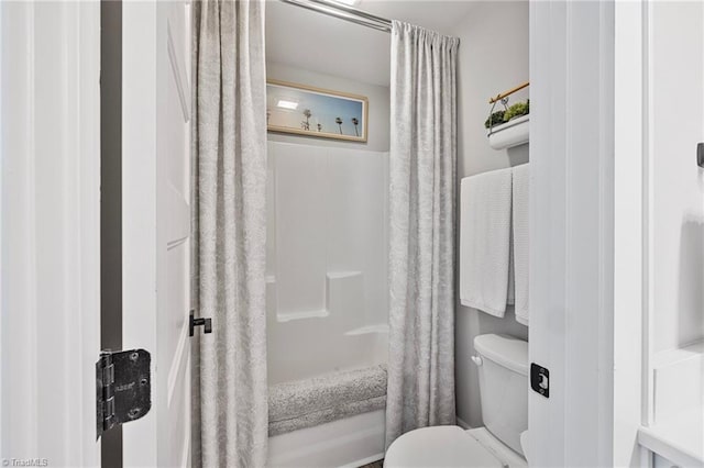 bathroom featuring shower / tub combo with curtain and toilet