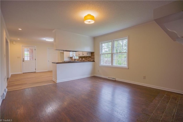 804 W 4th Ave, Lexington, NC 27292 - unfurnished living room with crown molding, wood finished floors, a textured ceiling, baseboards, and visible vents