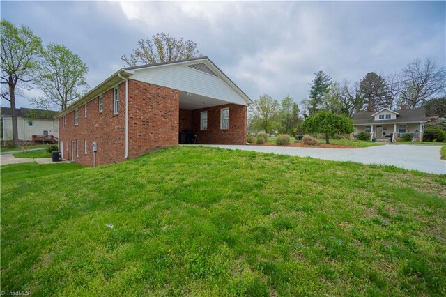 804 W 4th Ave, Lexington, NC 27292 - view of home's exterior with brick siding, concrete driveway, an attached carport, and a yard