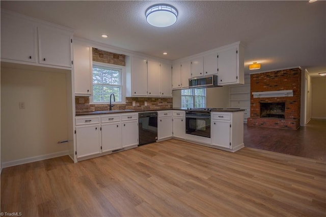 804 W 4th Ave, Lexington, NC 27292 - kitchen with white cabinetry, a sink, dark countertops, light wood-style flooring, and black appliances