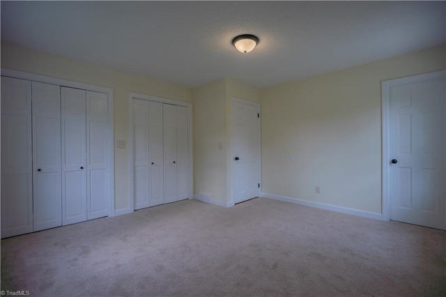 804 W 4th Ave, Lexington, NC 27292 - unfurnished bedroom with baseboards, multiple closets, and carpet