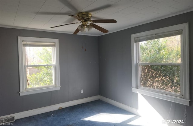 carpeted spare room with plenty of natural light, ornamental molding, and ceiling fan