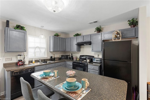 kitchen with visible vents, a sink, black appliances, under cabinet range hood, and dark countertops