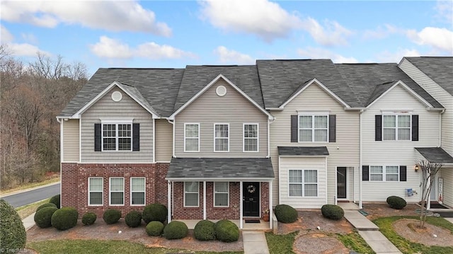 multi unit property with brick siding and a shingled roof